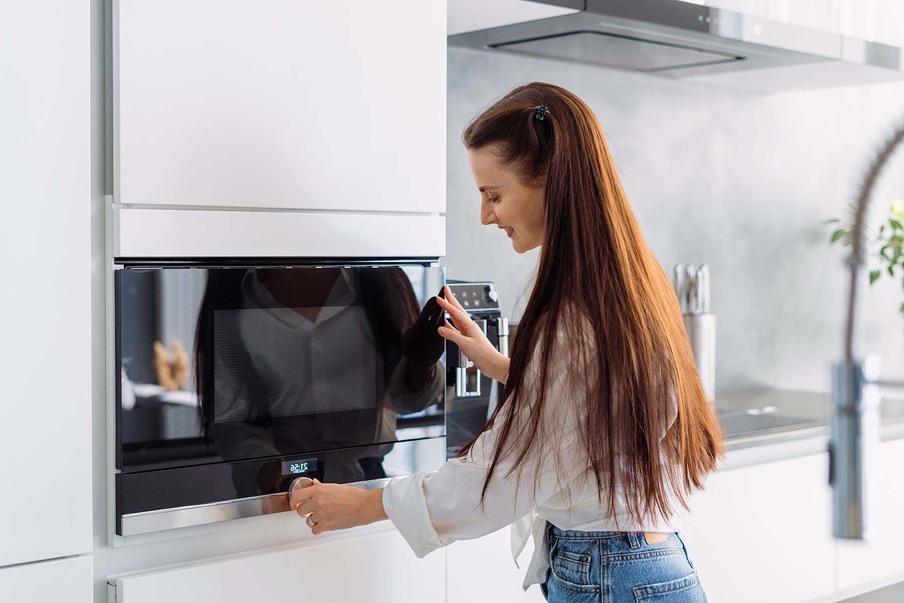 woman entering time on a built in microwave